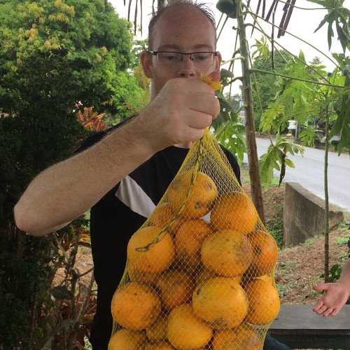 David holding a bag of oranges